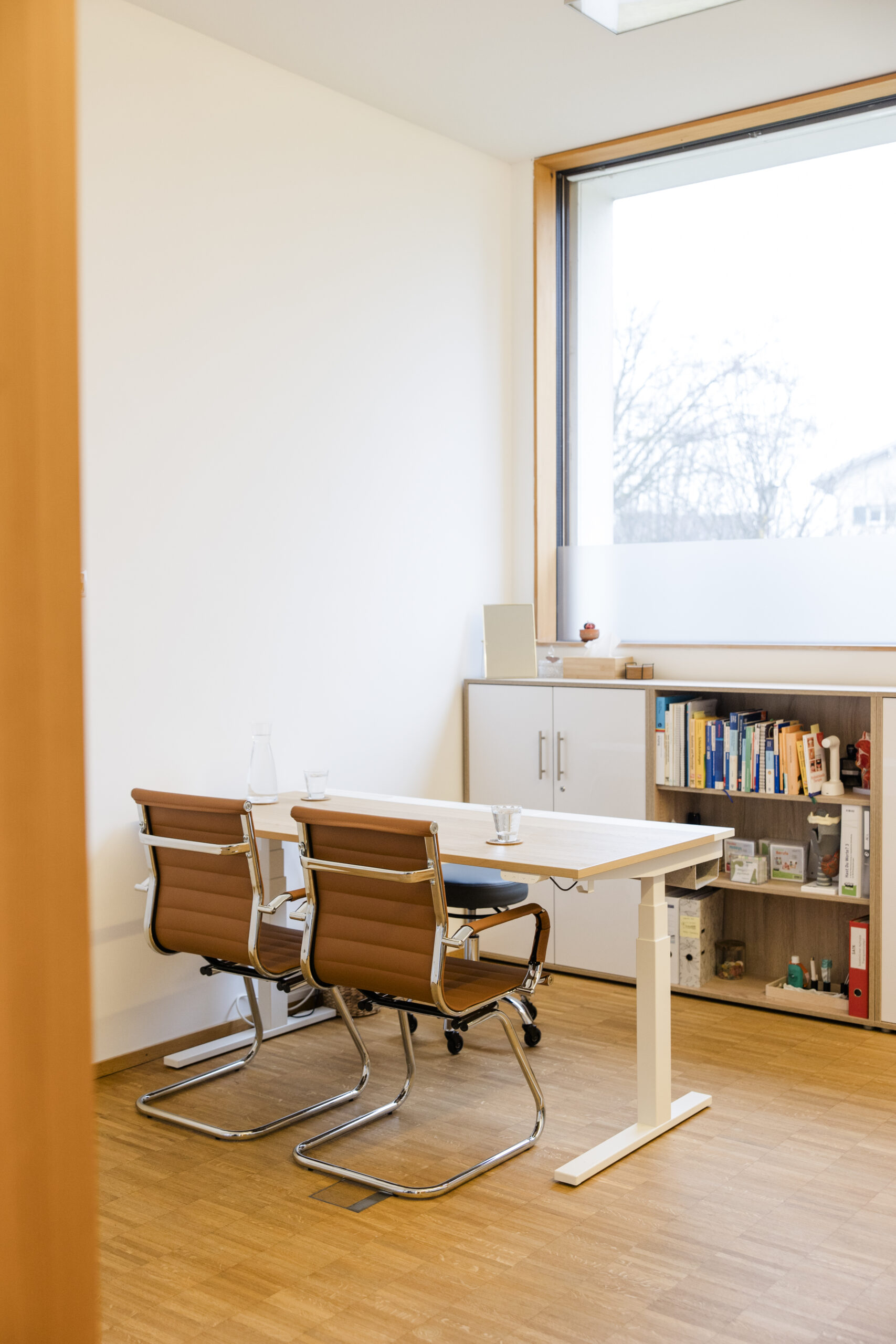 Bett im Logopädie-Behandlungsraum mit Kissen und Decke